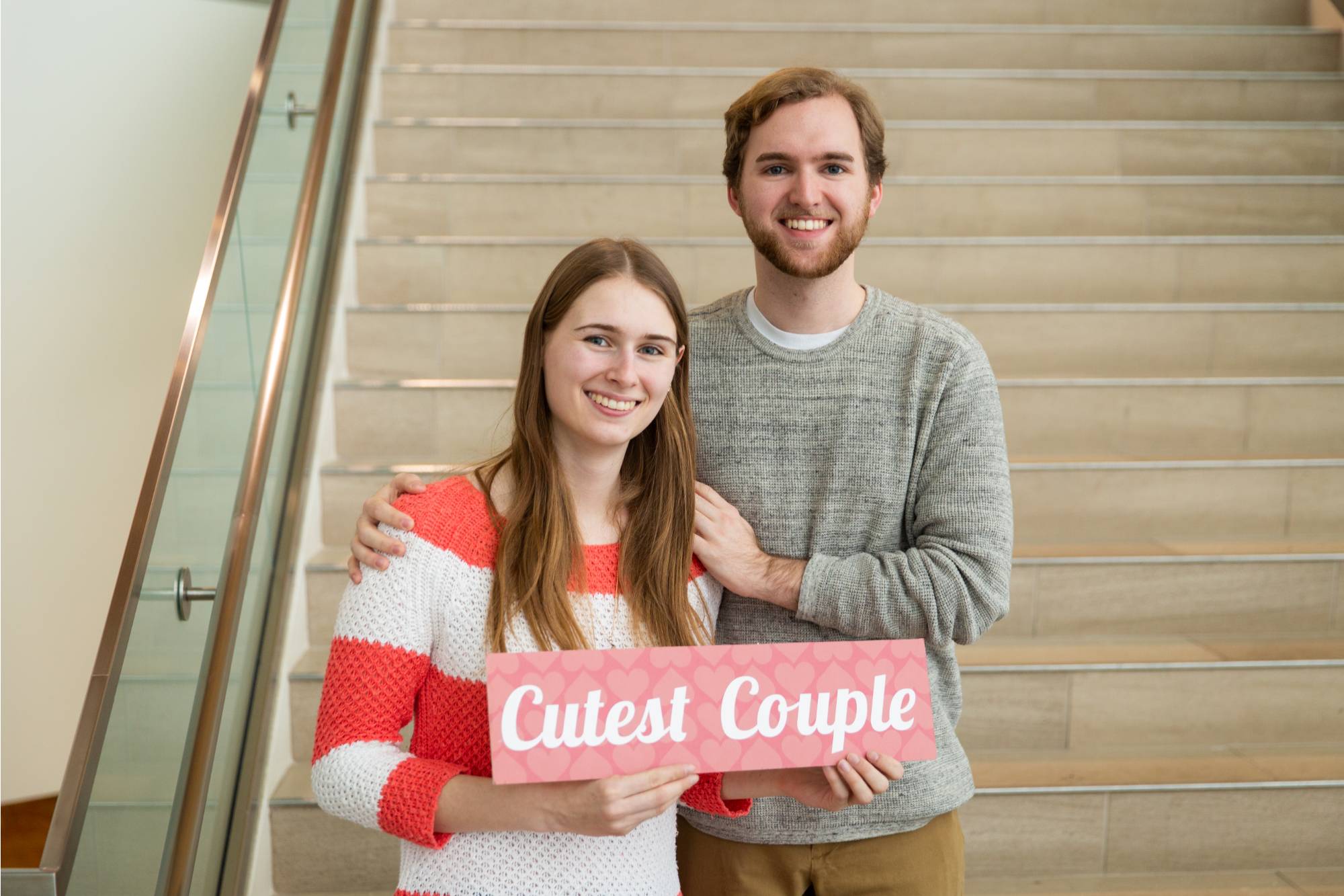 GVSU couple holding sign labeled "cutest couple"